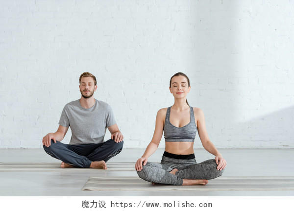 年轻男女在半的姿势下练习瑜伽健身男女健身运动双人瑜伽瑜伽打坐